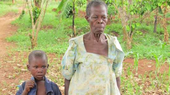 African Granny walking down a path with an African orphan boy