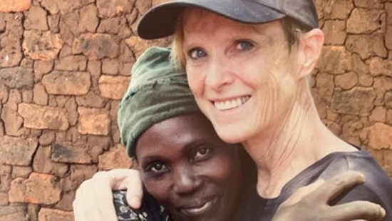 Founder Marcia Baugh hugging and African woman, both smiling